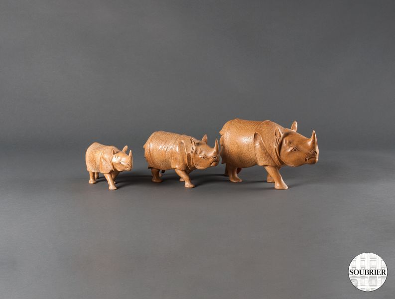 Trois rhinocéros en bois sculpté
